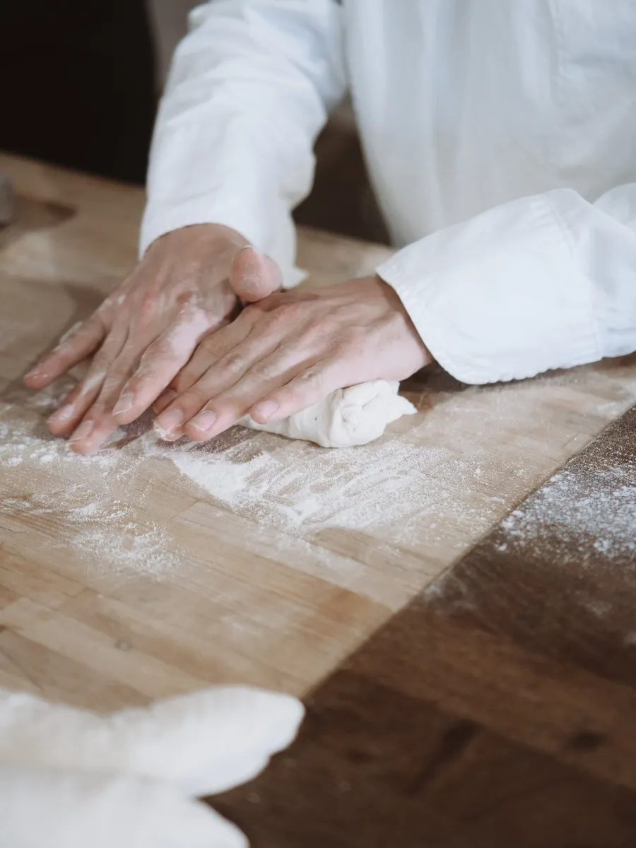 A baker's hands in flour at the bakehouse