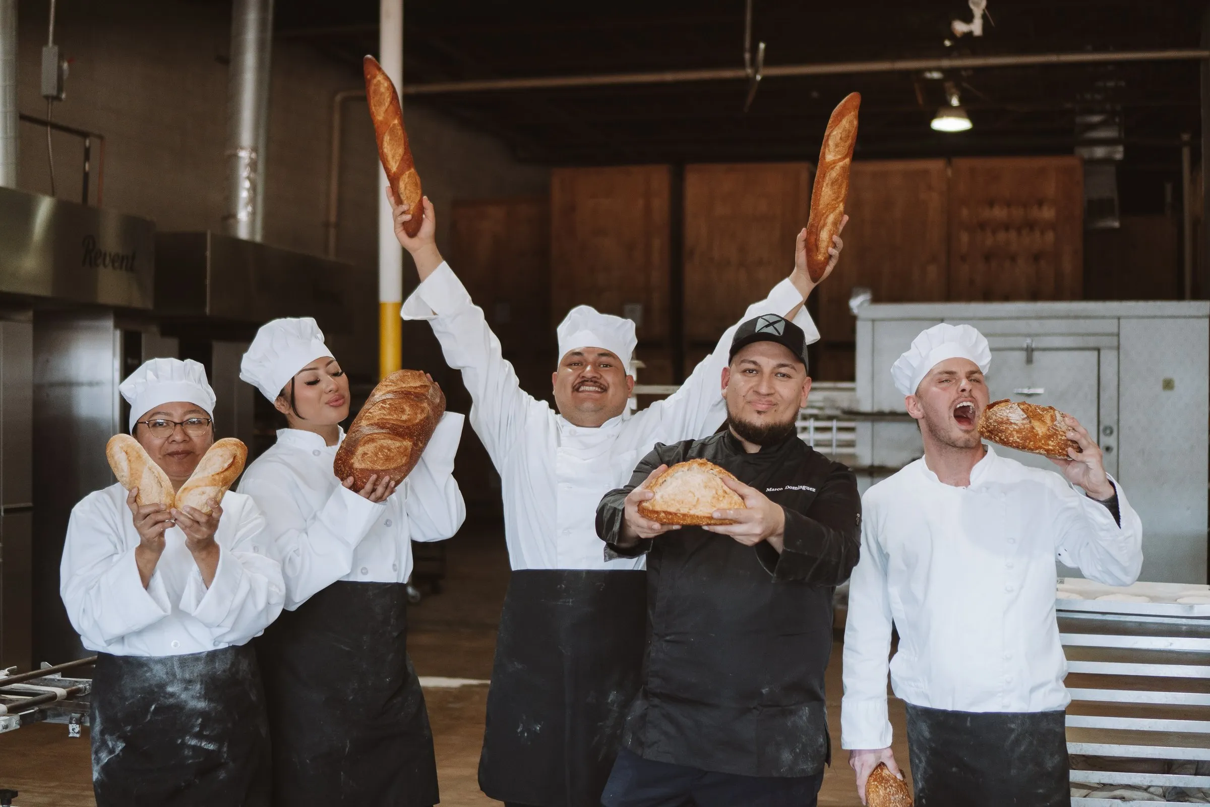 The bakehouse team holding up baguettes